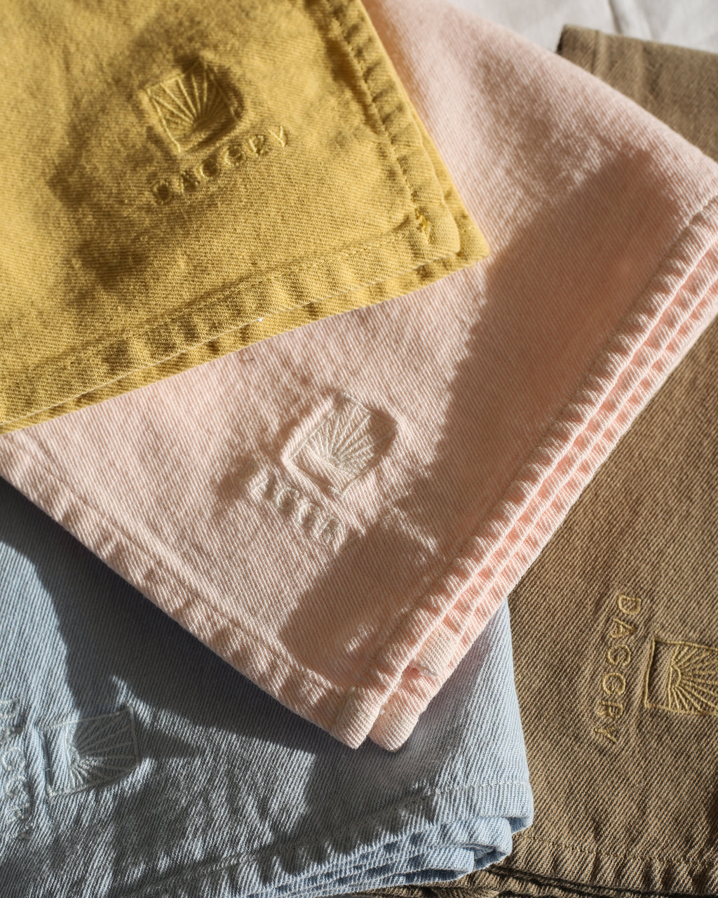 Stack of folded towels with a visible brand logo on a textured surface