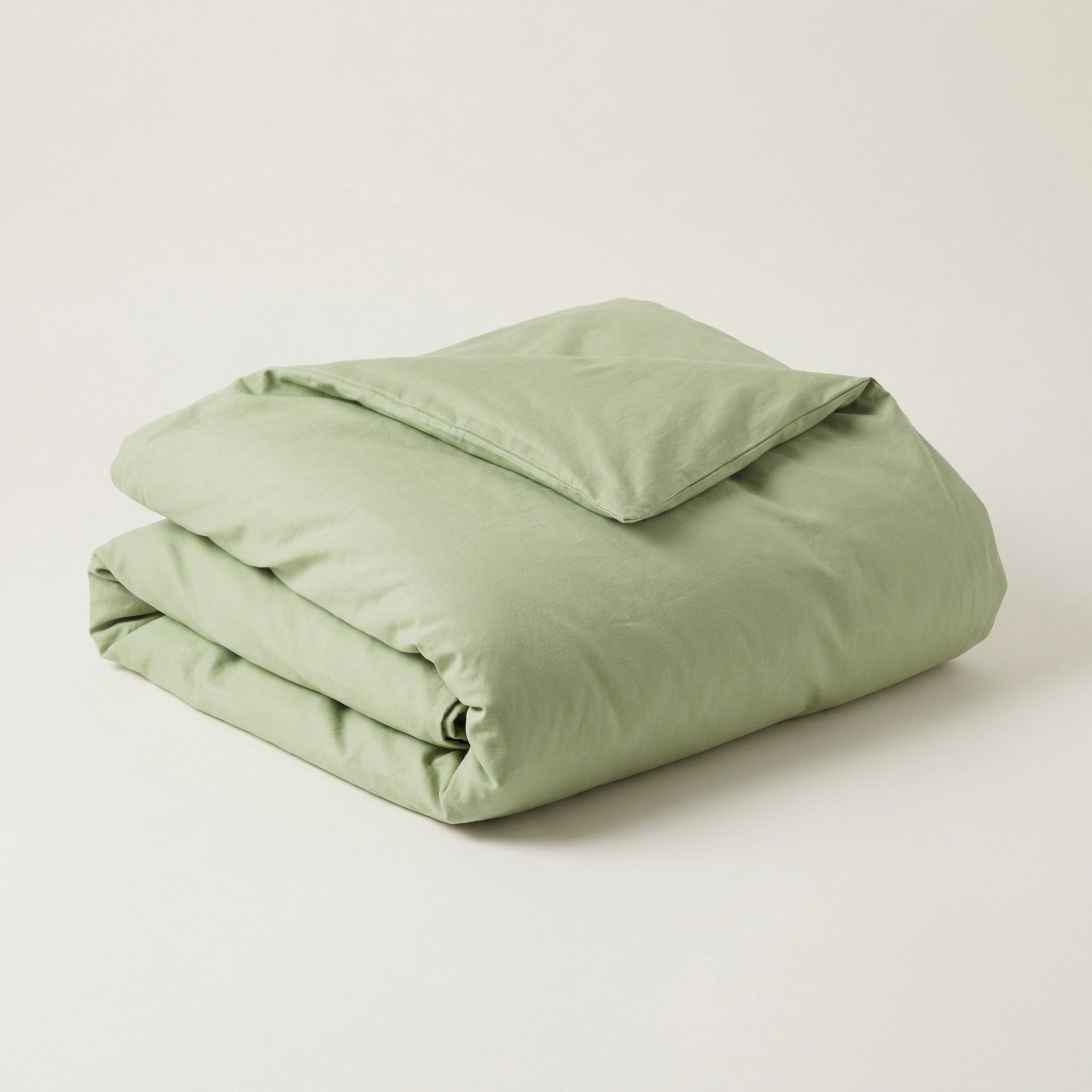 Folded spring green comforter on a white background
