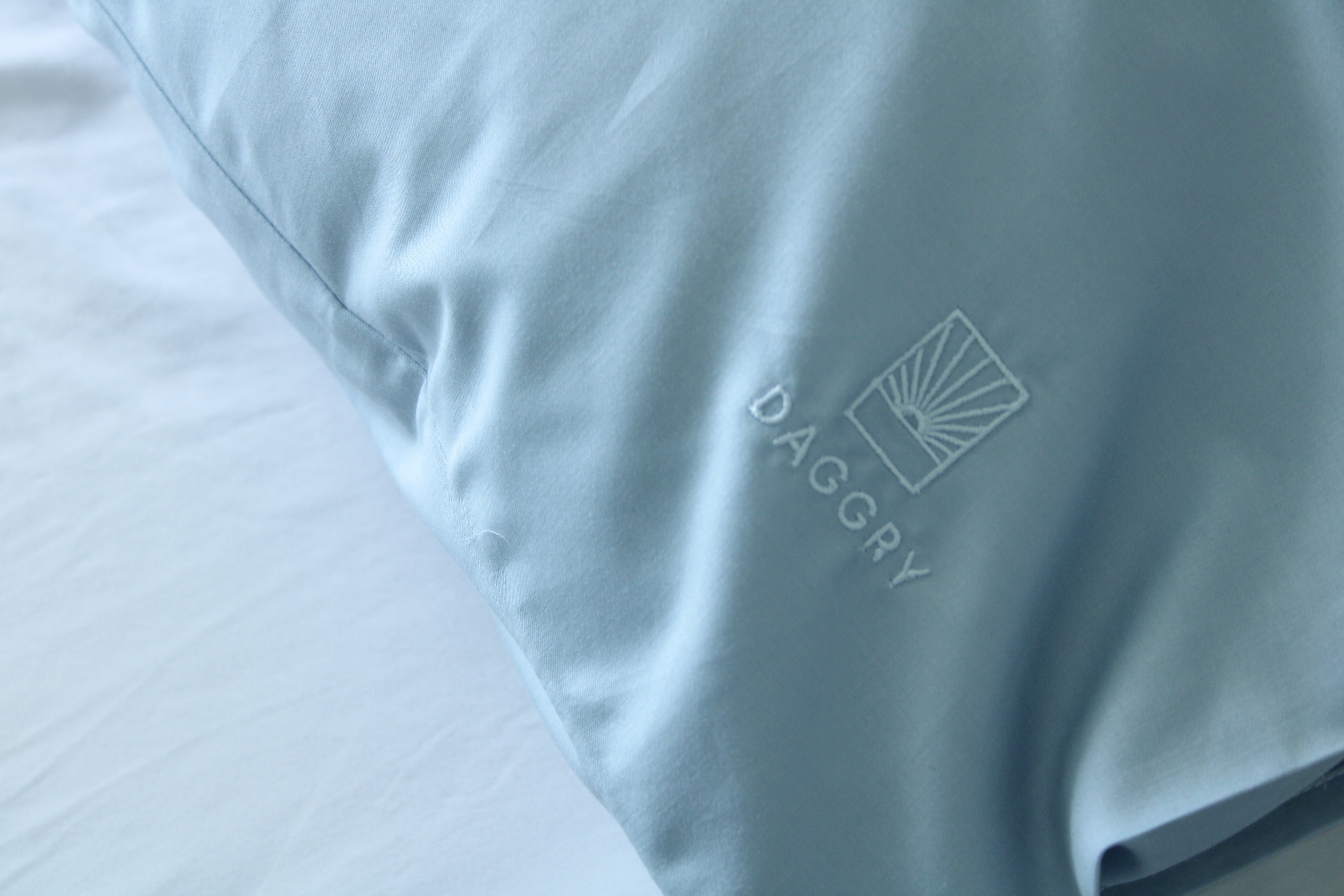 Light blue pillowcase with 'DAGGRY' logo on a white background