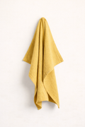 Mustard towel draped over a white surface